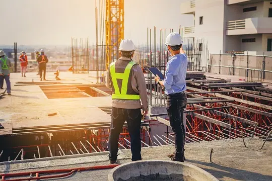 مهندس عمران در حال بررسی نقشه‌های ساختمانی و بررسی جزئیات فنی پروژه